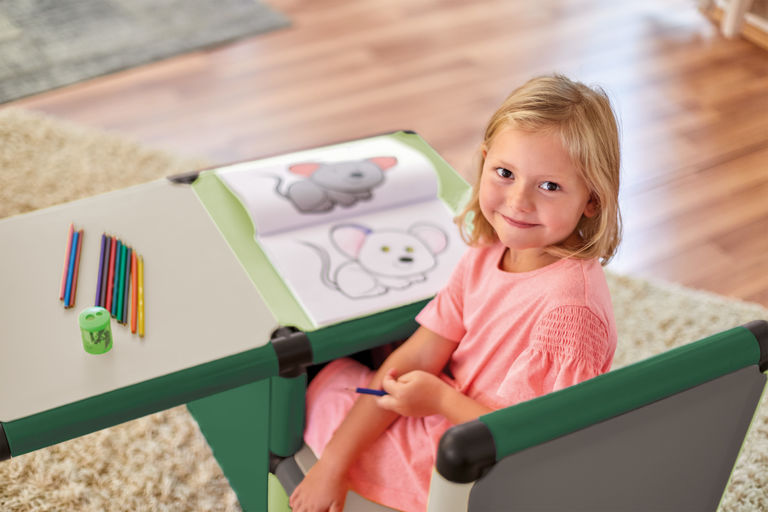 Girl drawing pictures sitting in a Quadro desk